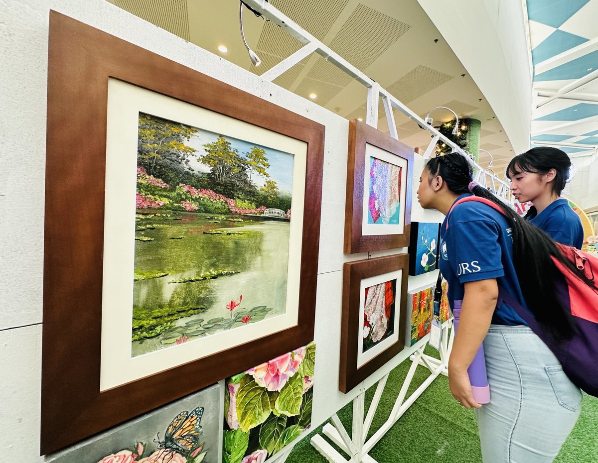 A student delves into the details of a painting.